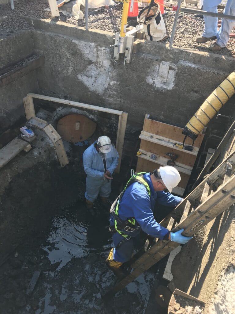 confined space entry man going down ladder to repair water and storm drain run off for catch basin