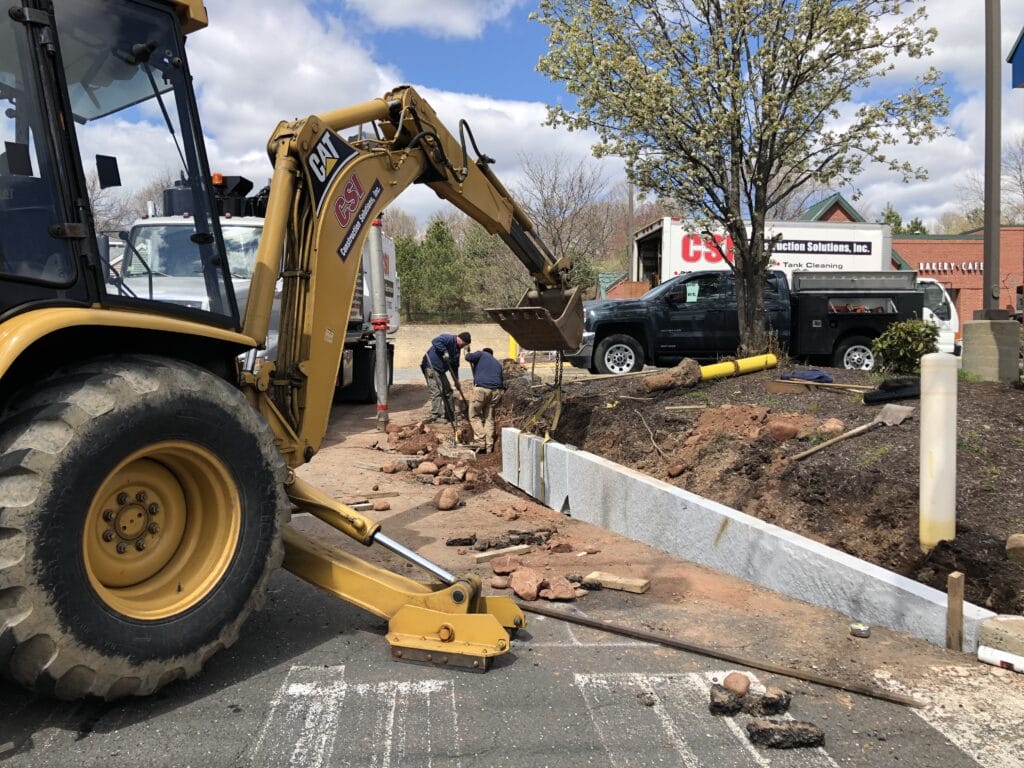 vac truck & traditional excavation curb installation for retail plaza in Manchester CT with backhoe and vac ruck