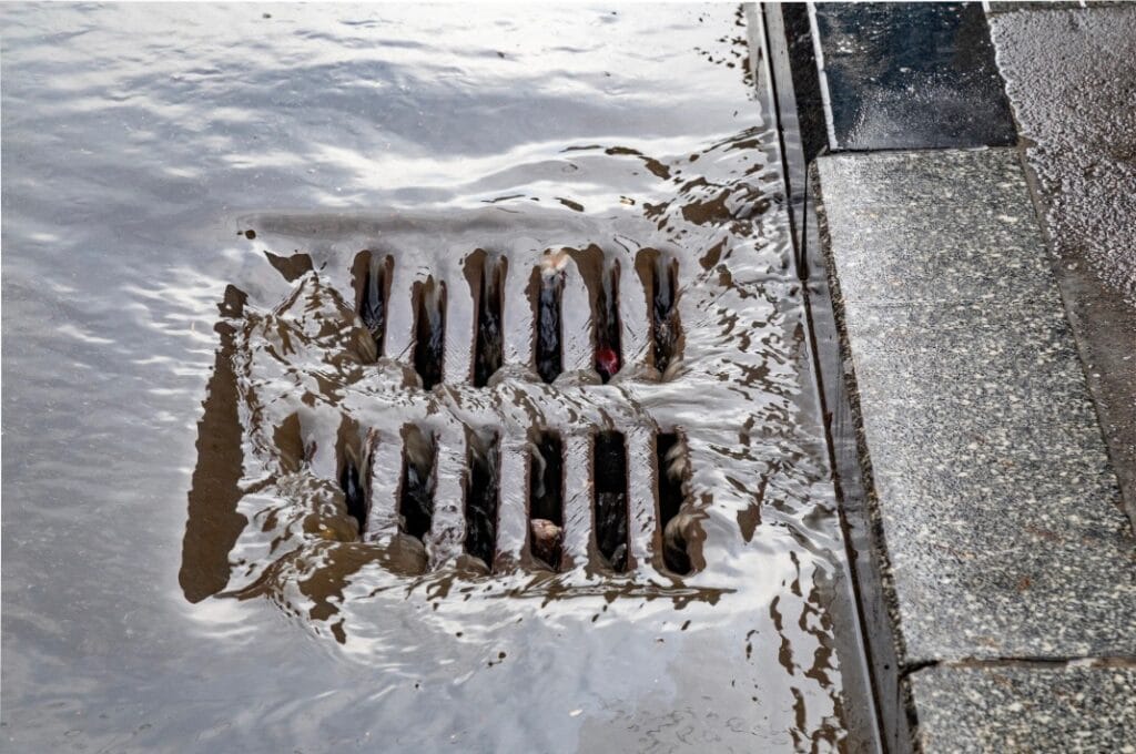 water and mud washing into a storm drain 