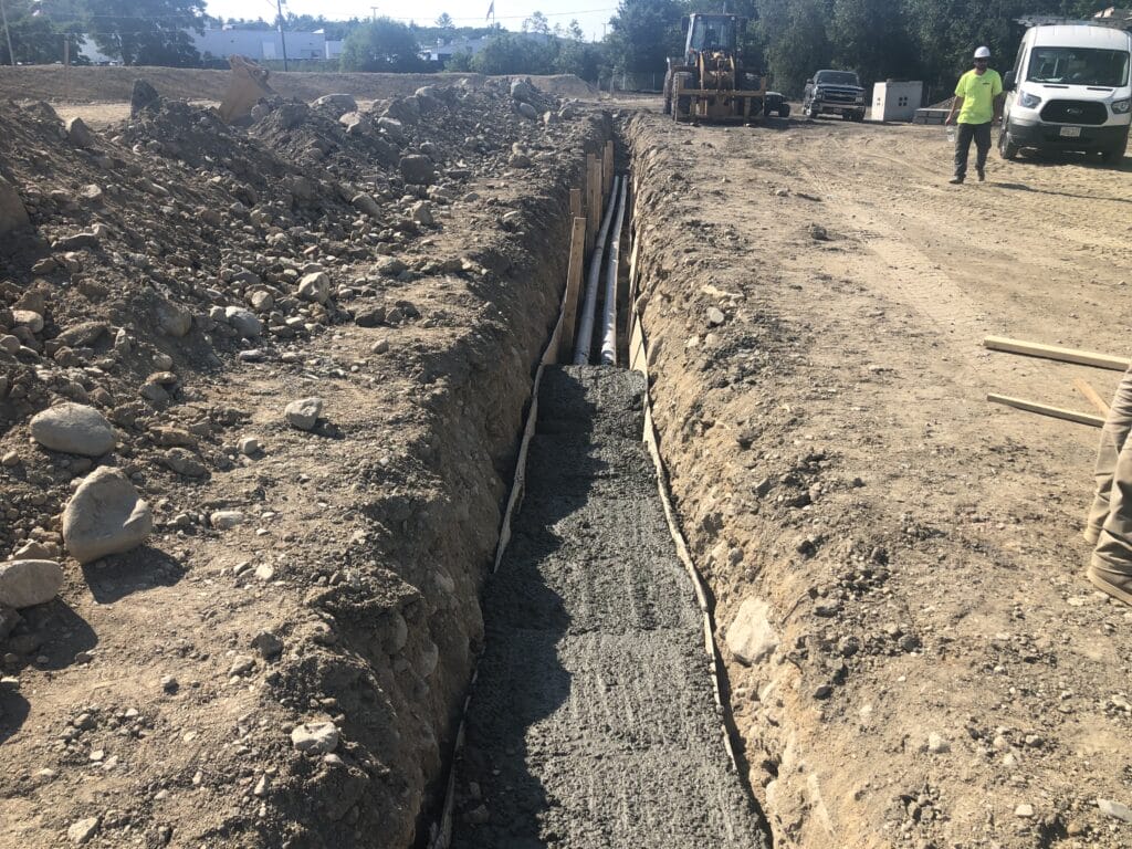 new utility line installation for electrical lines to run shopping plaza lights, shows trench and pipes installed for the lines to run and hold the cement base of the light pole