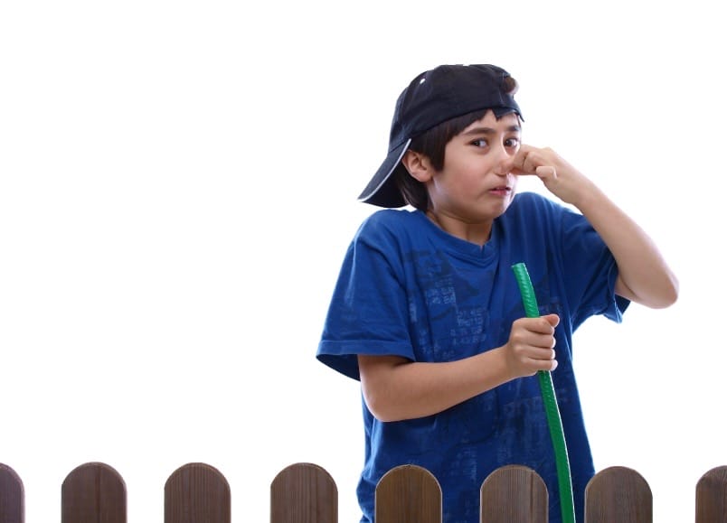 boy holding nose from bad odor outdoors from septic system failure