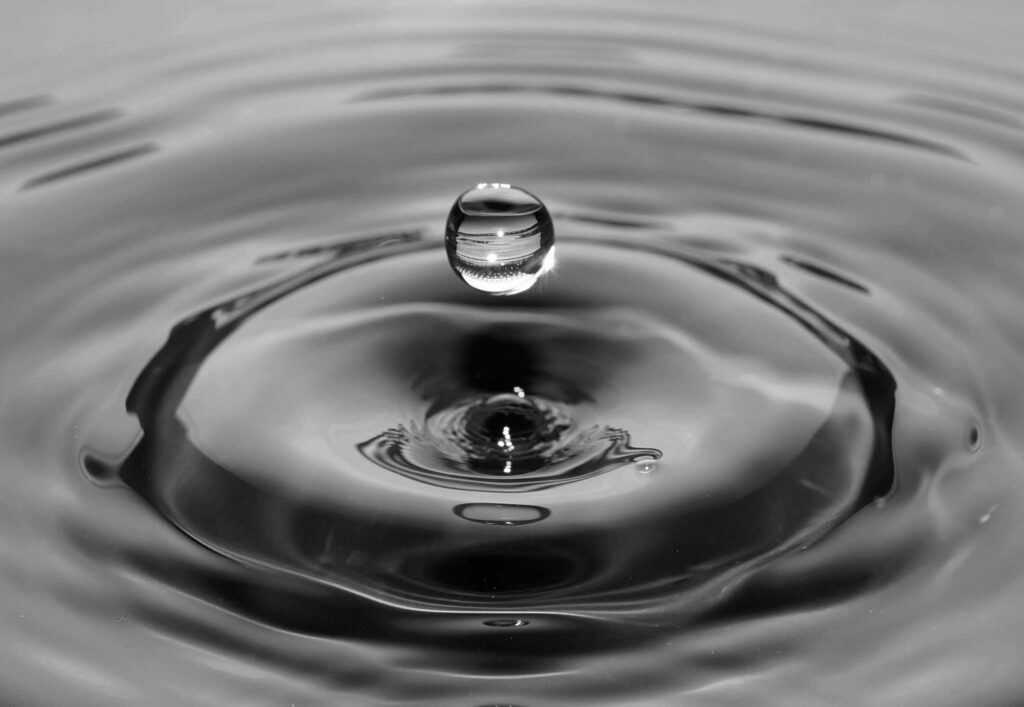 water droplet rippling before it hits a pool of water