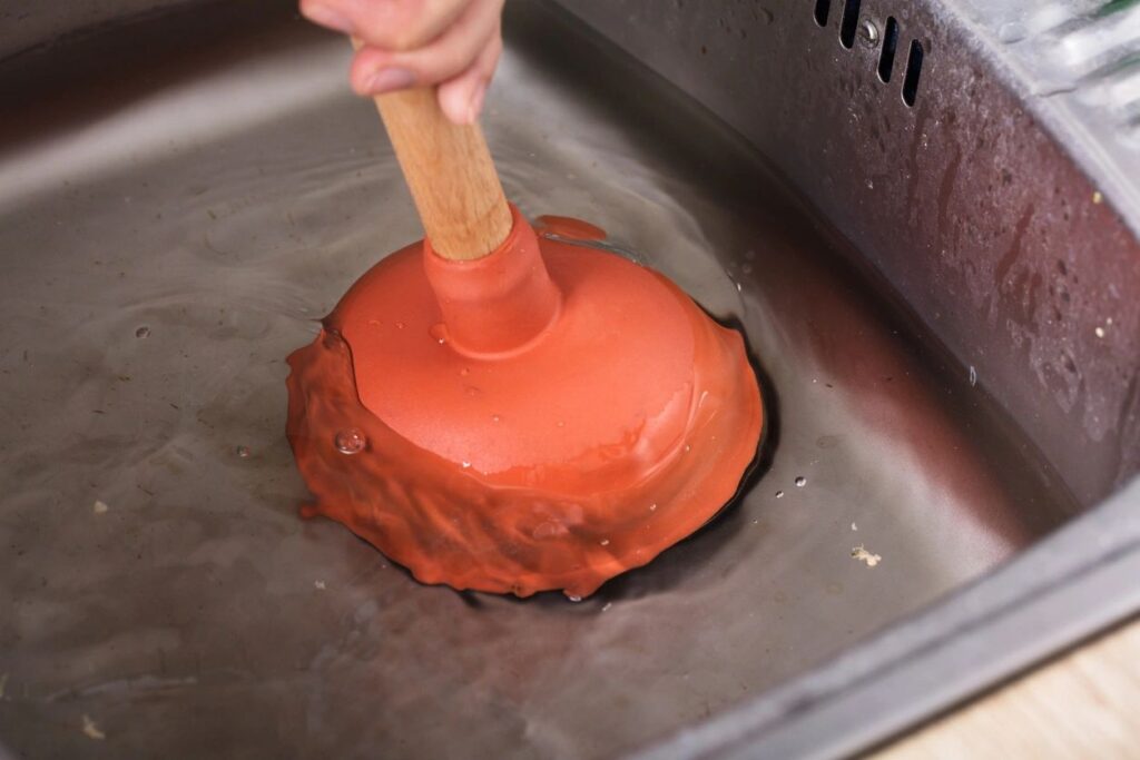 plunger in sink with running water